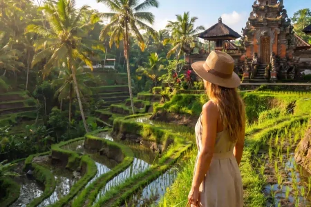 Solo woman overlooking a Balinese temple and green rice terraces in Bali